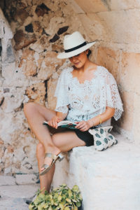 White Lace Top Worn With Scalloped Grey Shorts And A Classic White Panama Hat - Holiday Outfit Inspiration