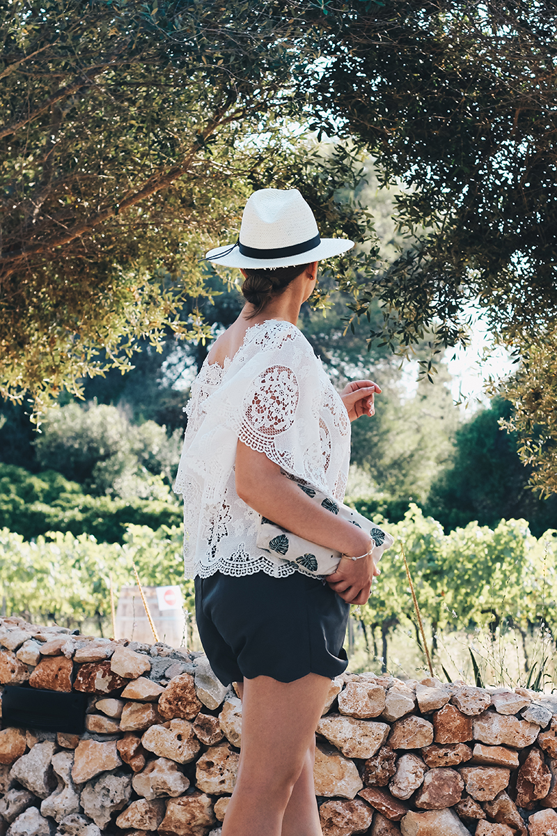 White Lace Top Worn With Scalloped Grey Shorts And A Classic White Panama Hat - Holiday Outfit Inspiration