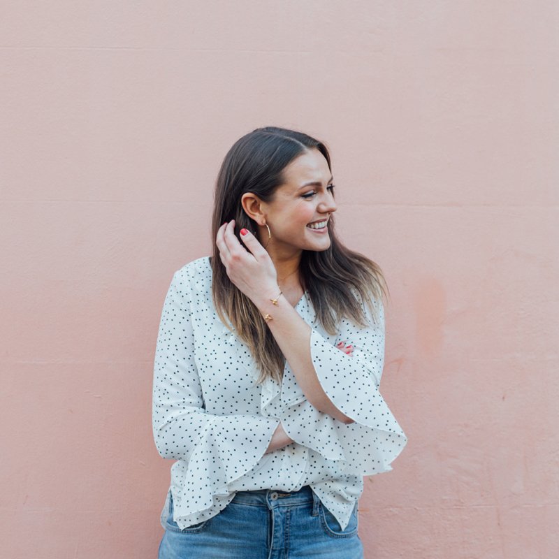 White Polka Dot Top Worn With Blue Girlfriend Jeans Against A Pink Wall Backdrop | Monica Beatrice Welburn | The Elgin Avenue Blog