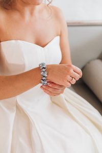 Bride putting on jewellery | Monica Beatrice Welburn Wedding Day
