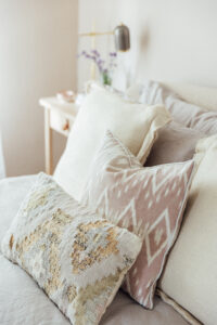 Layered Neutral Throw Pillows on Bouclé Bed from Feather & Black | Monica Beatrice Home Tour